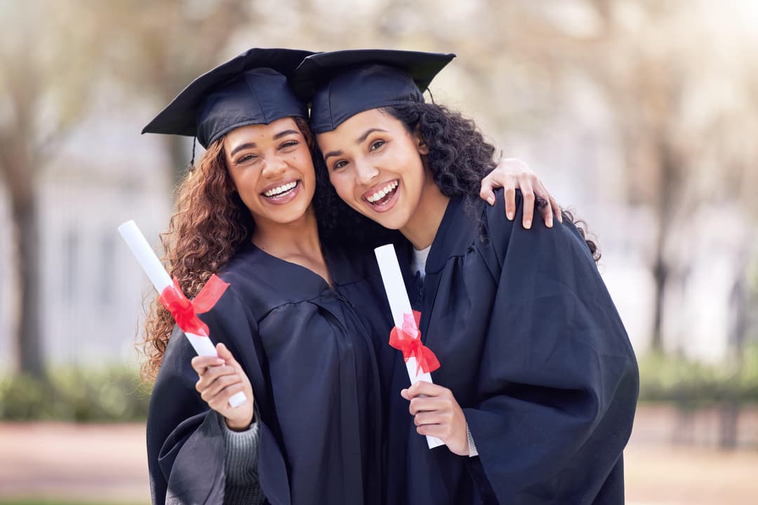 two young hispanic women hugging on graduation day